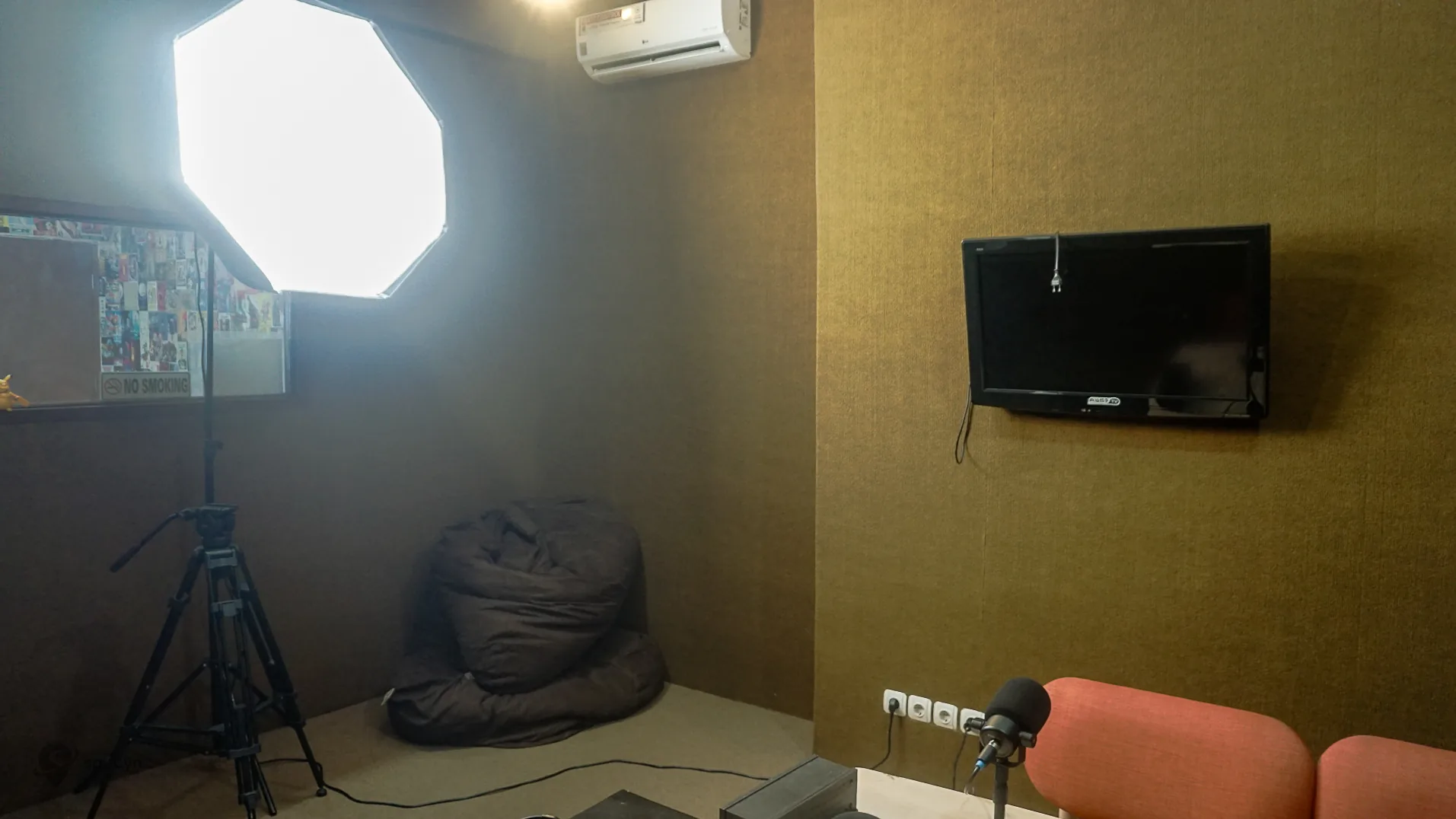 Setup studio podcast solo Jakarta dengan mikrofon, kamera, lighting, dan monitor