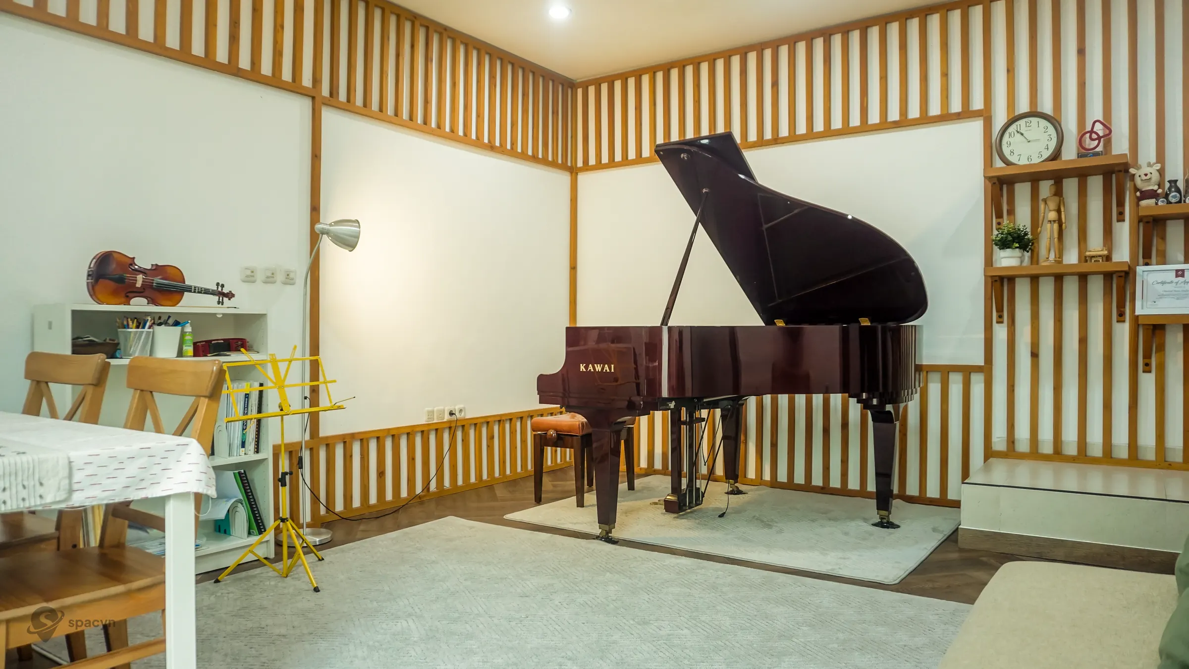 Studio musik dengan piano dan ruang latihan yang perlu disesuaikan dengan format pemain